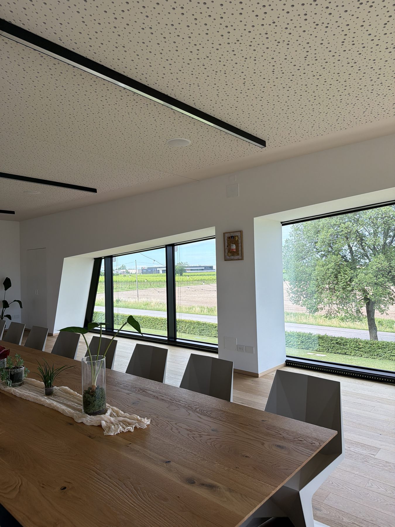 The TreZero tasting room: a long wooden table in front of large windows overlooking the vineyards
