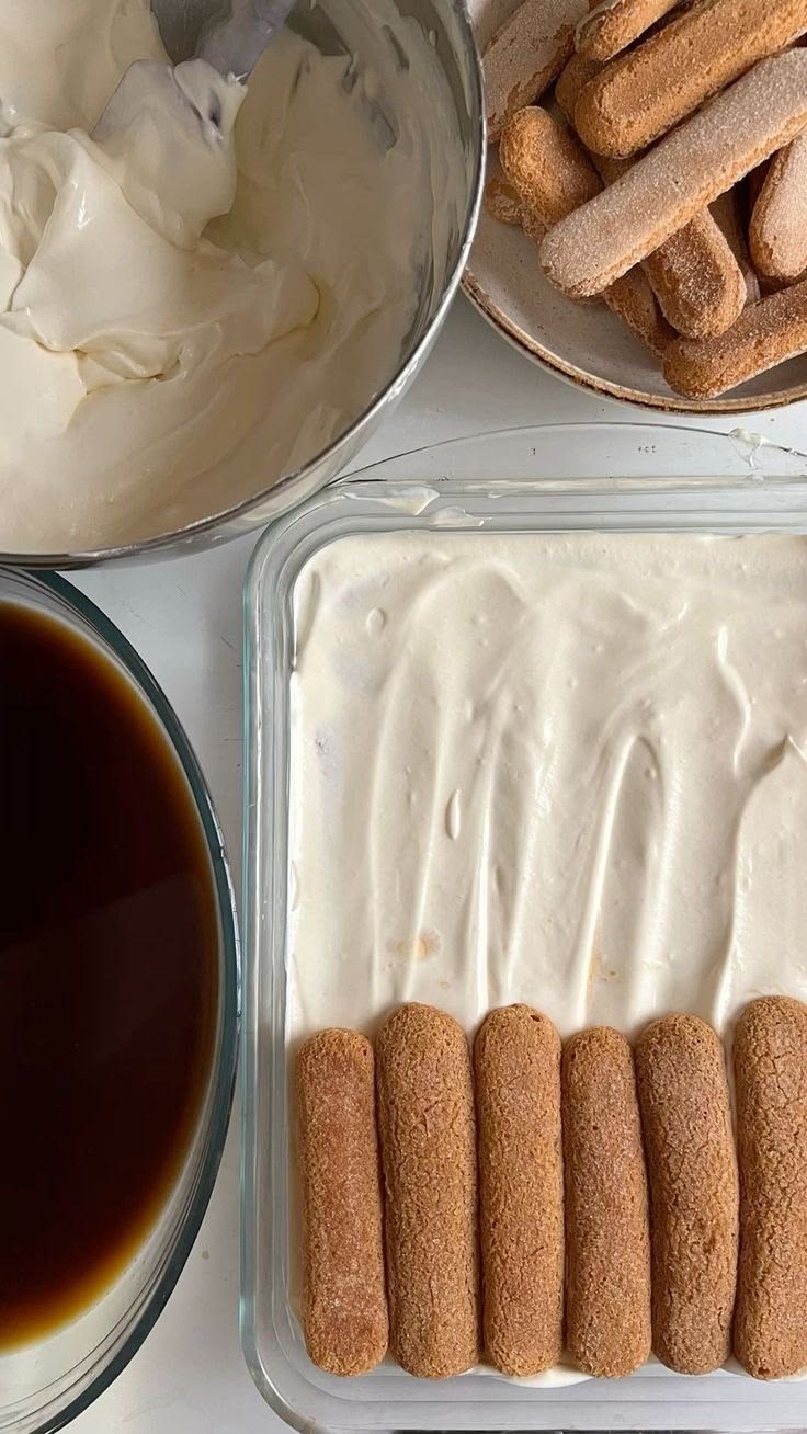 Assembling tiramisù with savoiardi, mascarpone cream and coffee